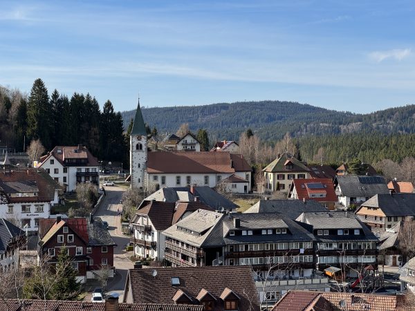 Kirche und Pfarrhaus auf dem Hügel, umgeben von Häusern